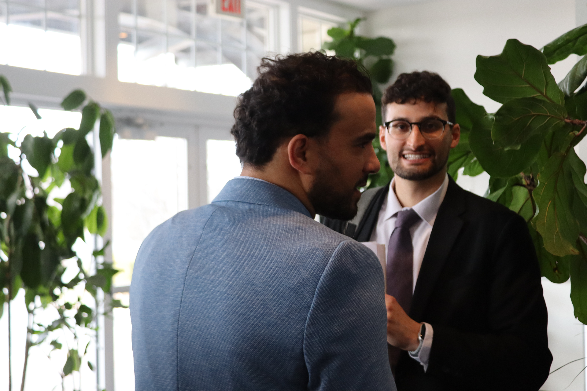Two Cornerstone professionals in conversation beside a window at a company conference